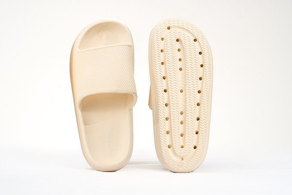 Cream-colored slide sandal with perforated sole.