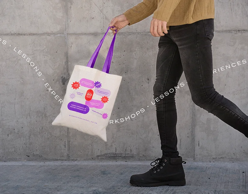 Person walking with tote bag branded with The Cocoa Bean logo and design.