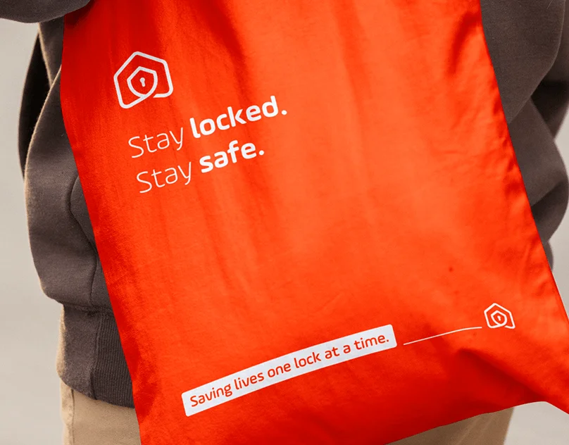 Red tote bag with Stay Locked Stay Safe campaign design.